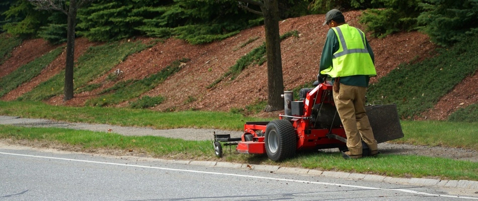 A professional mowing side of the road on a commercial property in Pinellas County, FL.